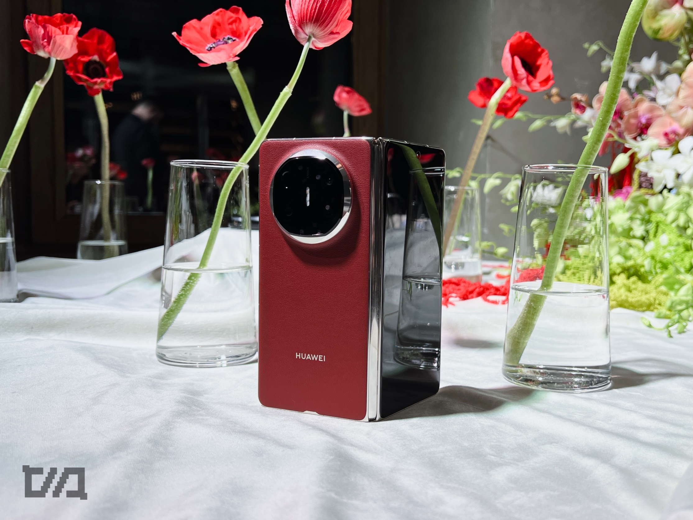 ΠΠ° ΡΠΎΡΠΎ ΠΊΡΠ°ΡΠ½ΡΠΉ ΡΠΌΠ°ΡΡΡΠΎΠ½ HUAWEI Π½Π° Π±Π΅Π»ΠΎΠΌ ΡΡΠΎΠ»Π΅ ΡΡΠ΄ΠΎΠΌ Ρ ΠΏΡΠΎΠ·ΡΠ°ΡΠ½ΡΠΌΠΈ Π²Π°Π·Π°ΠΌΠΈ.
