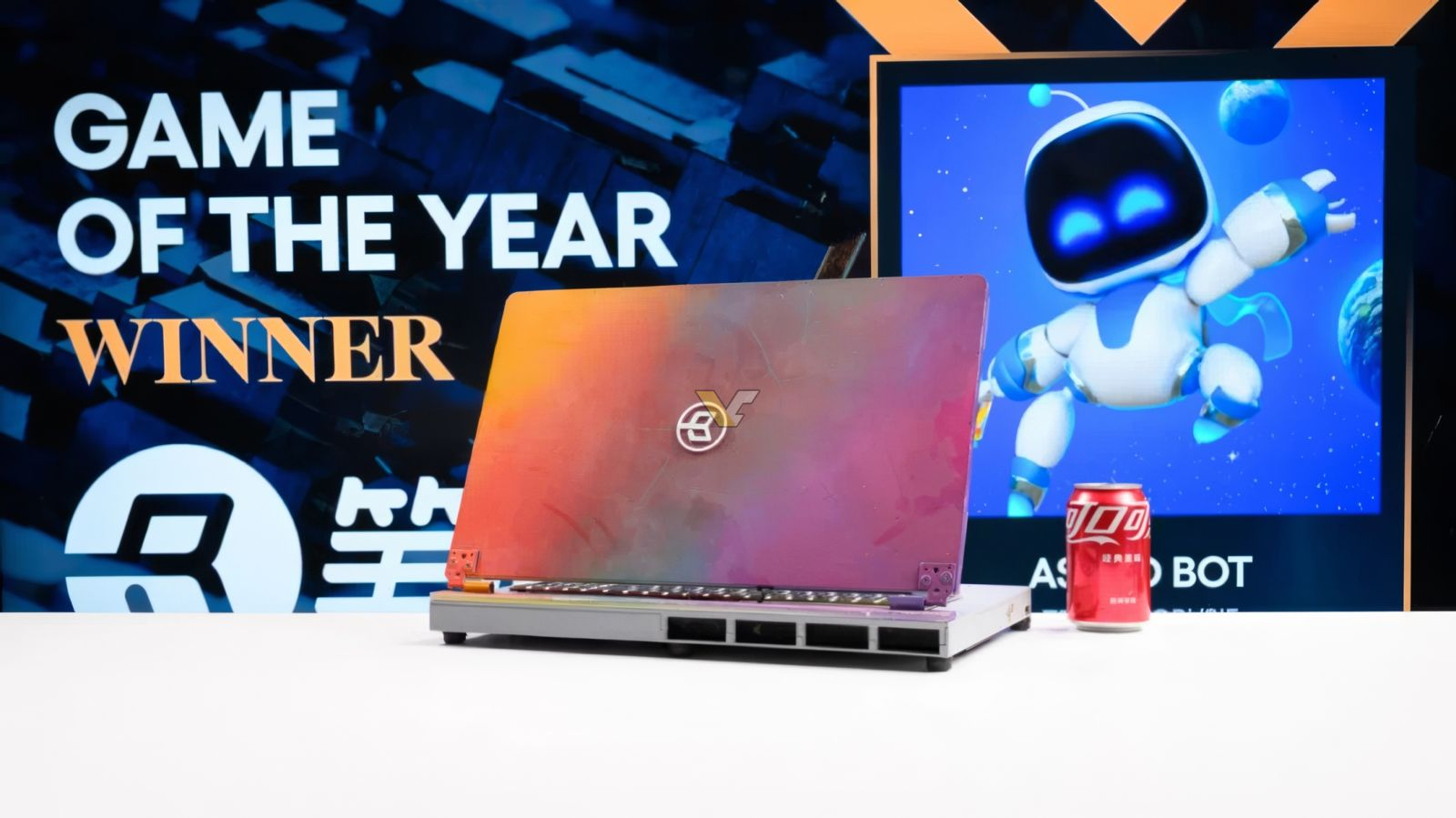 ΠΠ° ΡΠΎΡΠΎ Π½ΠΎΡΡΠ±ΡΠΊ ROG, ΠΌΠΎΠ΄-ΠΊΠΎΠ½ΡΠΎΠ»Ρ PS5 Ρ ΡΠΊΡΠ°Π½ΠΎΠΌ, ΡΠΎΠ±ΠΎΡ ΠΈ Π±Π°Π½ΠΊΠ° Red Bull.