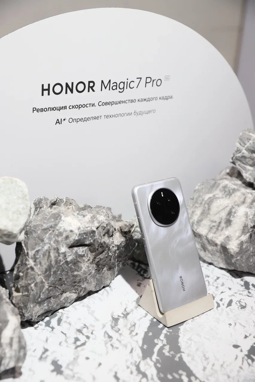 ΠΠ° ΡΠΎΡΠΎ β ΡΠΌΠ°ΡΡΡΠΎΠ½ Honor Magic 7 Pro Π² ΡΠ΅ΡΠ΅Π±ΡΠΈΡΡΠΎΠΌ ΠΊΠΎΡΠΏΡΡΠ΅ Π½Π° ΠΏΠΎΠ΄ΡΡΠ°Π²ΠΊΠ΅ ΡΡΠ΄ΠΎΠΌ Ρ ΡΠΏΠ°ΠΊΠΎΠ²ΠΊΠΎΠΉ.