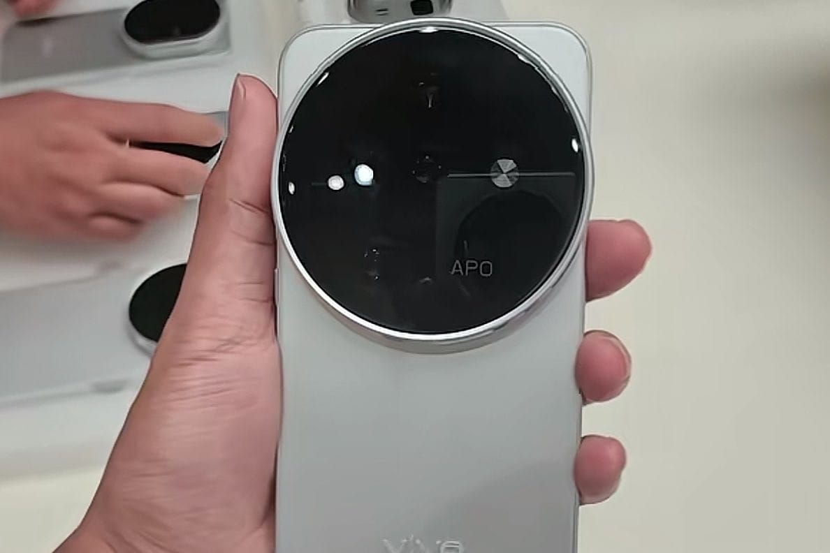 Π‘ΠΌΠ°ΡΡΡΠΎΠ½ vivo Ρ Π±ΠΎΠ»ΡΡΠΈΠΌ ΠΊΡΡΠ³Π»ΡΠΌ Π±Π»ΠΎΠΊΠΎΠΌ ΠΊΠ°ΠΌΠ΅Ρ, Π½Π°Π΄ΠΏΠΈΡΡΡ APO ΠΈ Π»ΠΎΠ³ΠΎΡΠΈΠΏΠΎΠΌ.